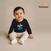 Babybody für Mädchen in Schwarz mit Motiv „Klein aber wild“, getragen von einem Kind – Wunderknirps.