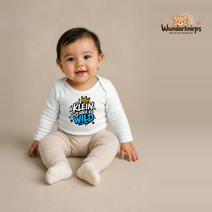 Babybody für Mädchen in Weiß mit Motiv „Klein aber wild“, getragen von einem Kind – Wunderknirps.