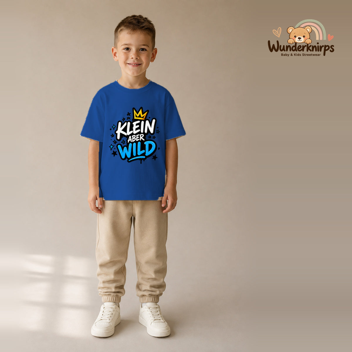 T-Shirt für Jungen in Blau mit Motiv „Klein aber wild“, getragen von einem Kind – Wunderknirps.