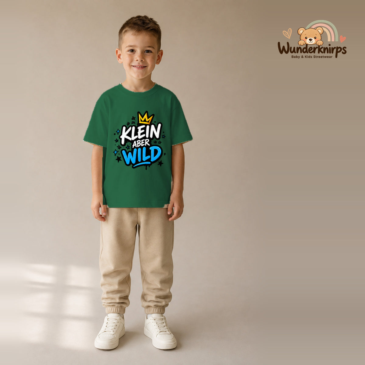T-Shirt für Jungen in Grün mit Motiv „Klein aber wild“, getragen von einem Kind – Wunderknirps.