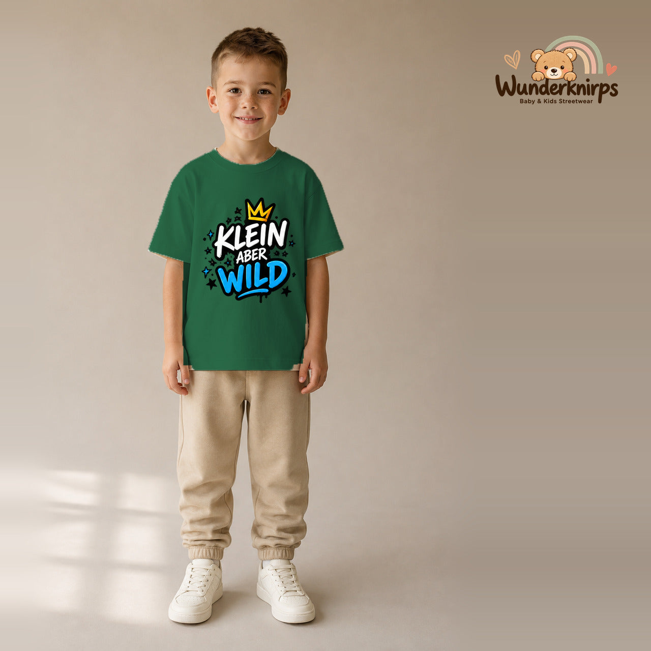 T-Shirt für Jungen in Grün mit Motiv „Klein aber wild“, getragen von einem Kind – Wunderknirps.
