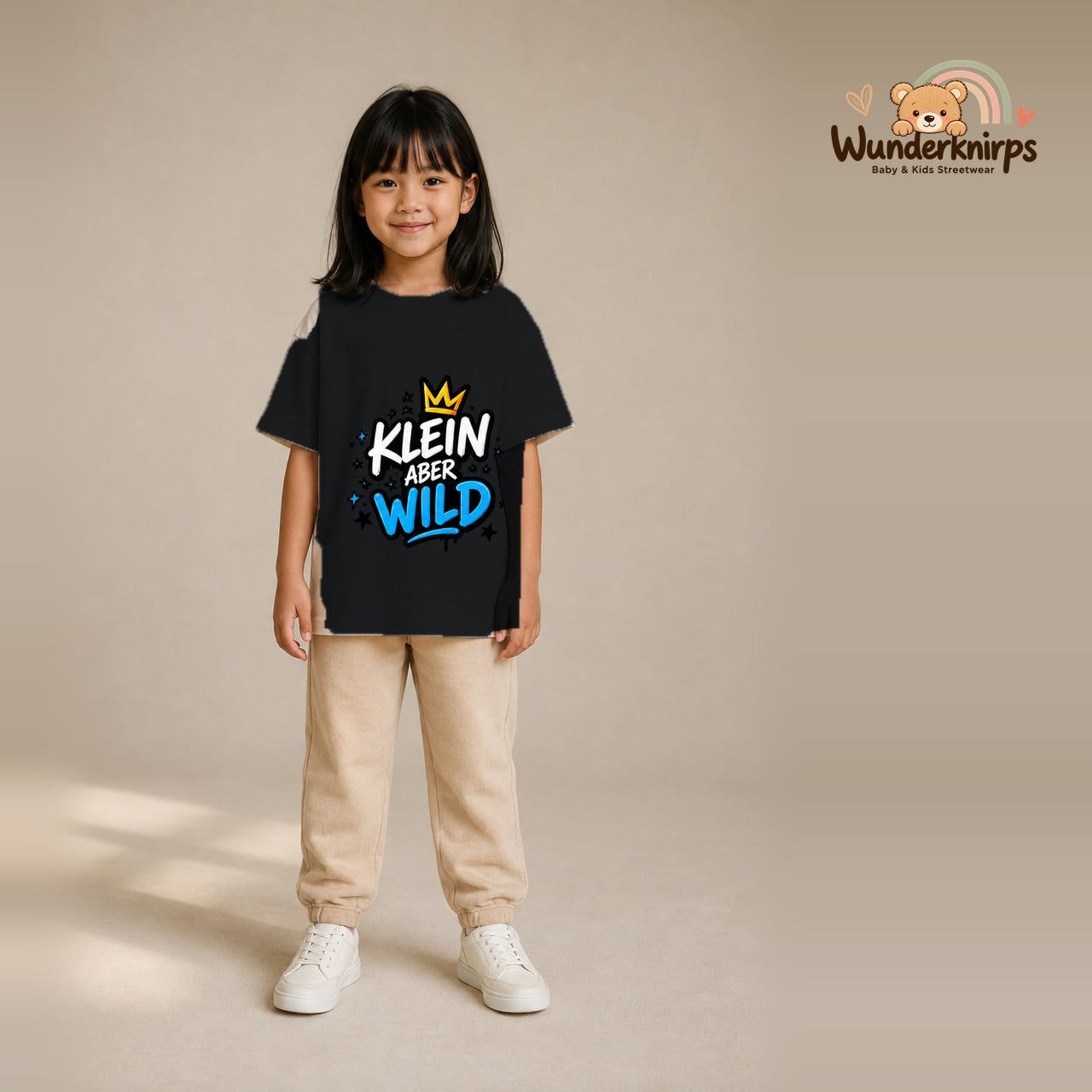 T-Shirt für Mädchen in Schwarz mit Motiv „Klein aber wild“, getragen von einem Kind – Wunderknirps.