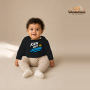 Babybody für Jungen in Schwarz mit Motiv „Klein laut legendär“, getragen von einem Kind – Wunderknirps.