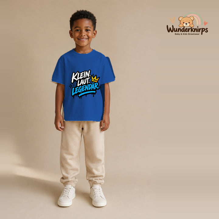 T-Shirt für Jungen in Blau mit Motiv „Klein laut legendär“, getragen von einem Kind – Wunderknirps.