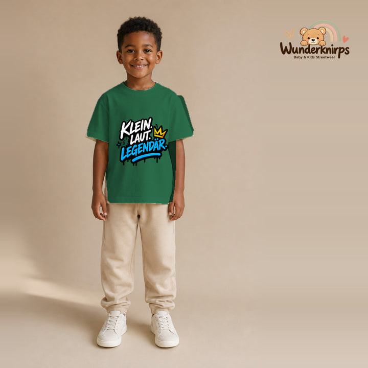 T-Shirt für Jungen in Grün mit Motiv „Klein laut legendär“, getragen von einem Kind – Wunderknirps.