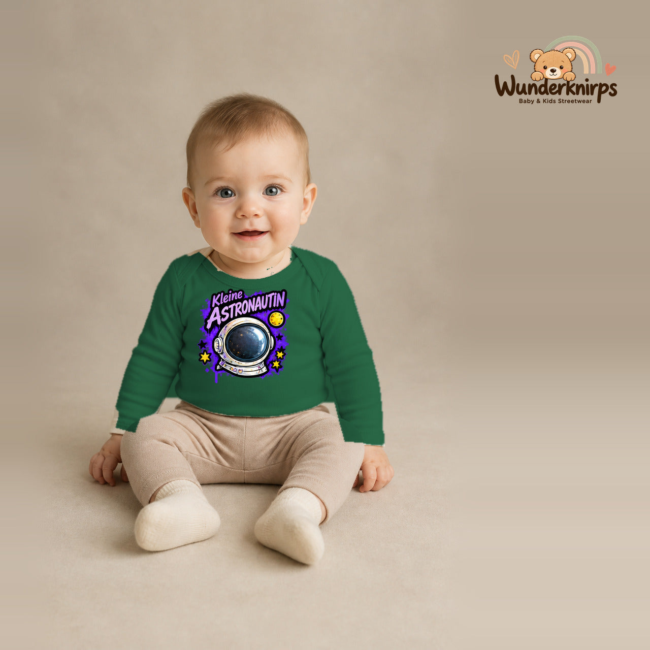 Babybody für Jungen in Grün mit Motiv „Kleine Astronautin“, getragen von einem Kind – Wunderknirps.