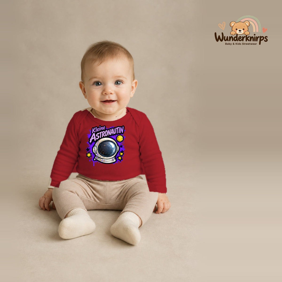 Babybody für Jungen in Rot mit Motiv „Kleine Astronautin“, getragen von einem Kind – Wunderknirps.