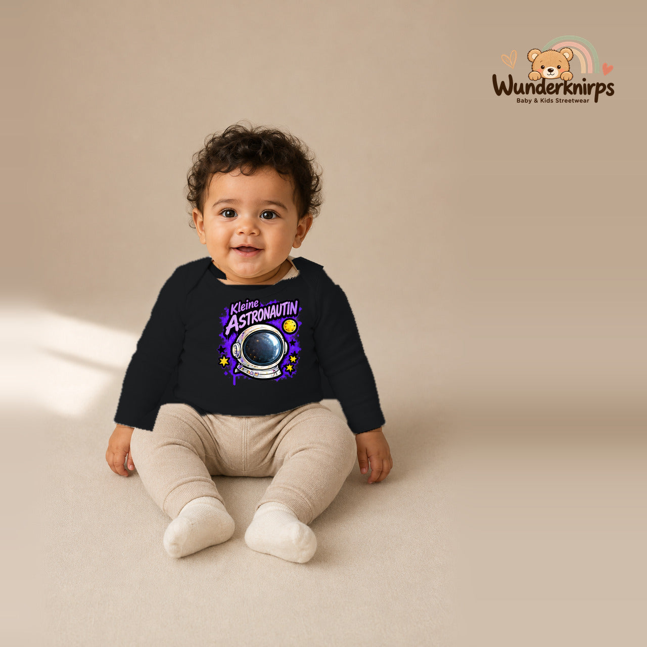 Babybody für Jungen in Schwarz mit Motiv „Kleine Astronautin“, getragen von einem Kind – Wunderknirps.
