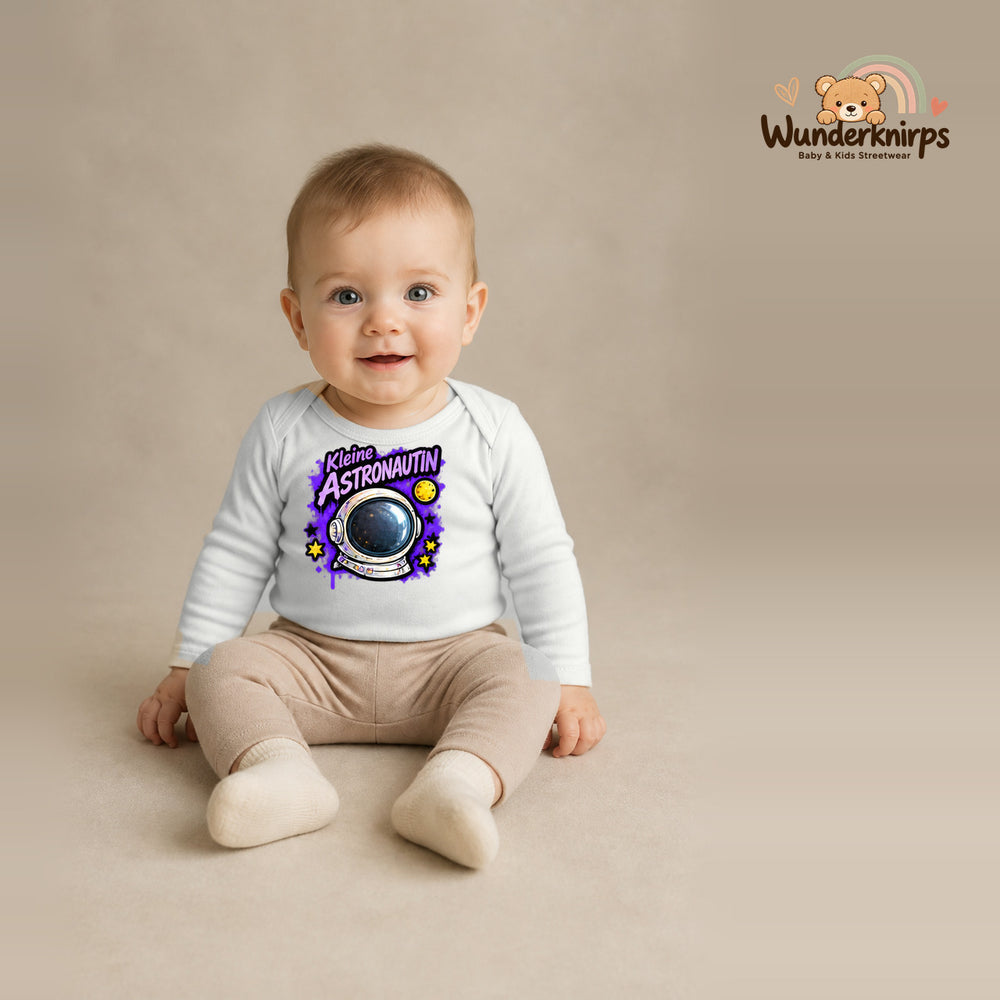 Babybody für Jungen in Weiß mit Motiv „Kleine Astronautin“, getragen von einem Kind – Wunderknirps.