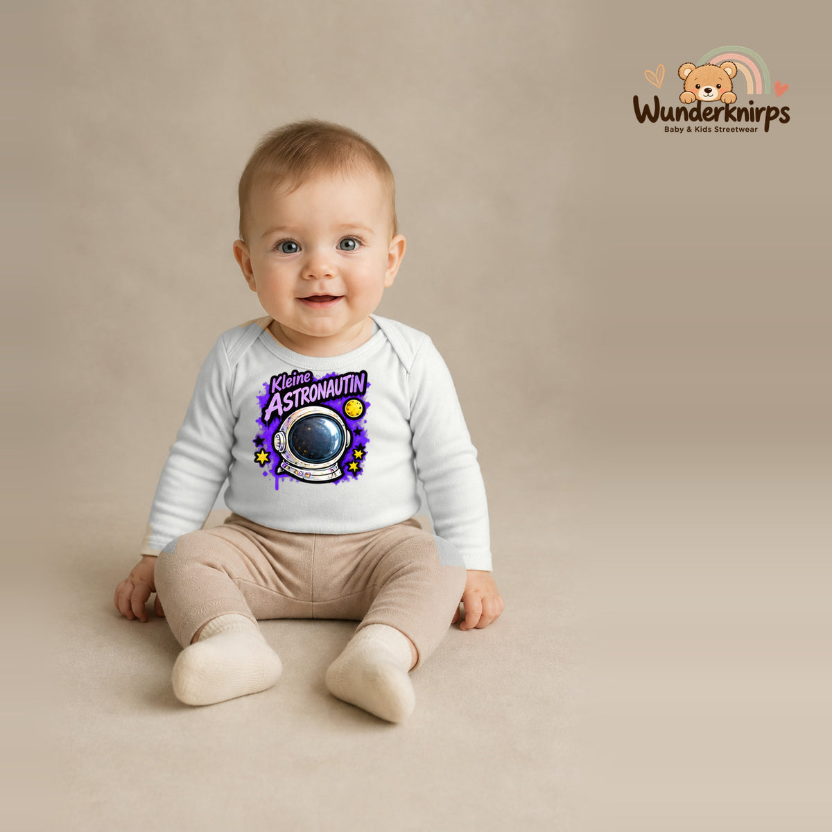 Babybody für Jungen in Weiß mit Motiv „Kleine Astronautin“, getragen von einem Kind – Wunderknirps.