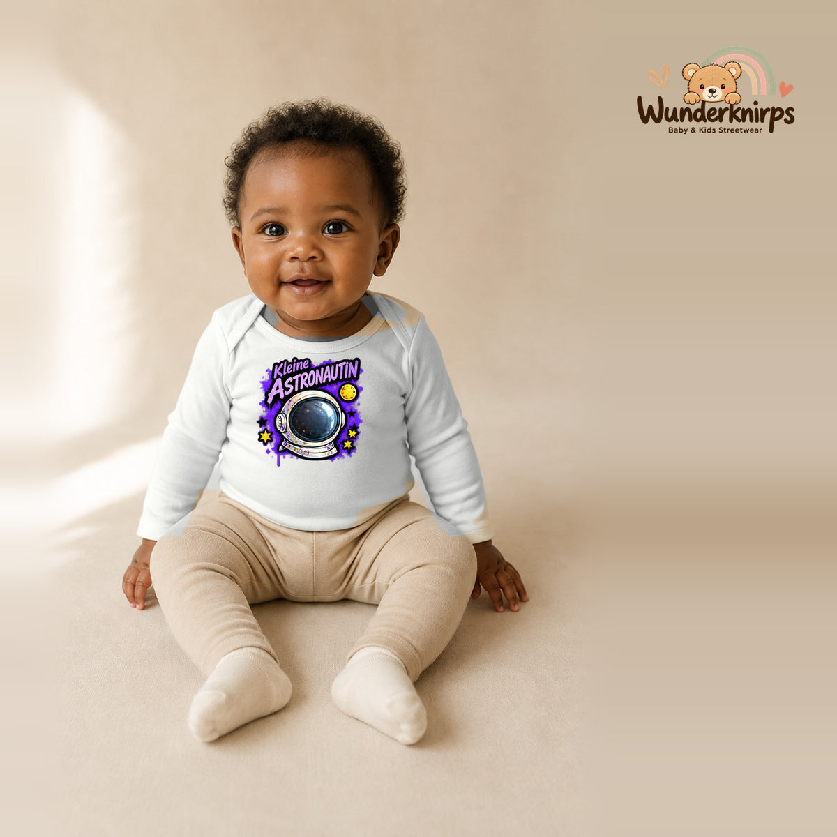 Babybody für Mädchen in Weiß mit Motiv „Kleine Astronautin“, getragen von einem Kind – Wunderknirps.