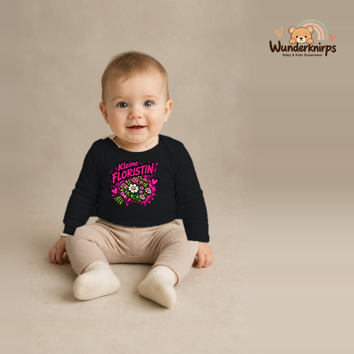 Babybody für Jungen in Schwarz mit Motiv „Kleine Floristin“, getragen von einem Kind – Wunderknirps.