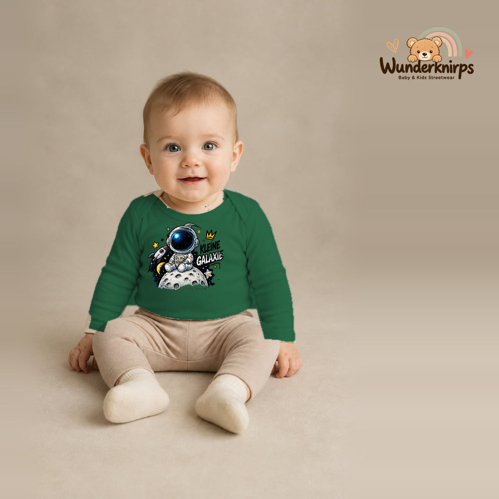 Babybody für Jungen in Grün mit Motiv „Kleine Galaxie“, getragen von einem Kind – Wunderknirps.