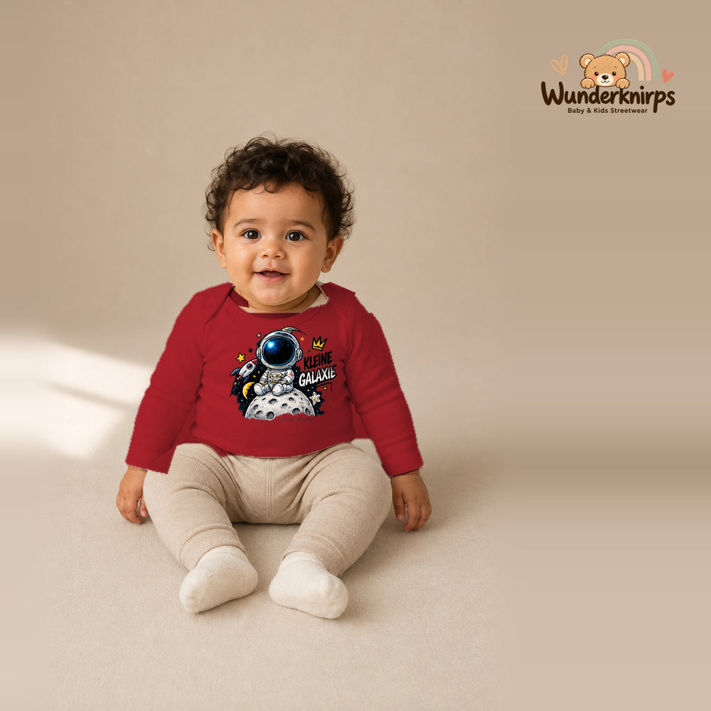 Babybody für Jungen in Rot mit Motiv „Kleine Galaxie“, getragen von einem Kind – Wunderknirps.