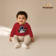 Babybody für Jungen in Rot mit Motiv „Kleine Galaxie“, getragen von einem Kind – Wunderknirps.