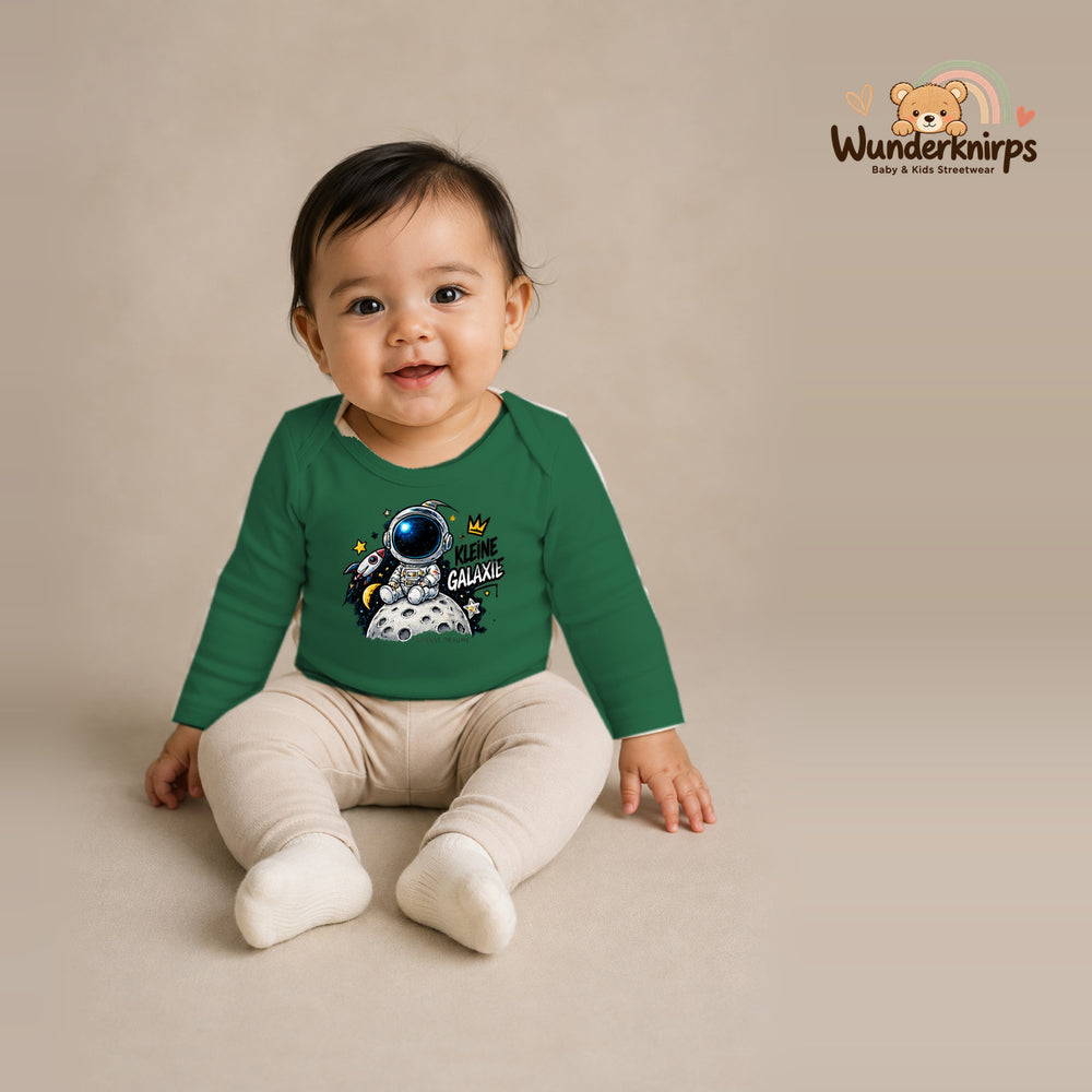 Babybody für Mädchen in Grün mit Motiv „Kleine Galaxie“, getragen von einem Kind – Wunderknirps.