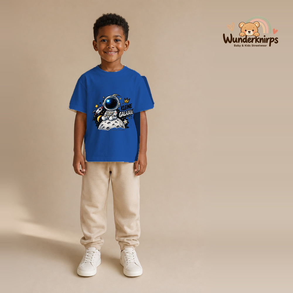 T-Shirt für Jungen in Blau mit Motiv „Kleine Galaxie“, getragen von einem Kind – Wunderknirps.