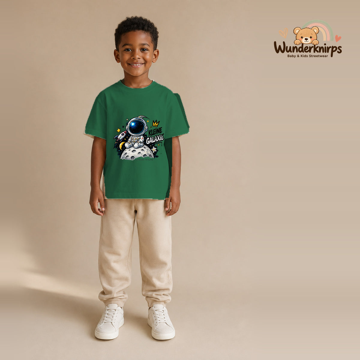 T-Shirt für Jungen in Grün mit Motiv „Kleine Galaxie“, getragen von einem Kind – Wunderknirps.