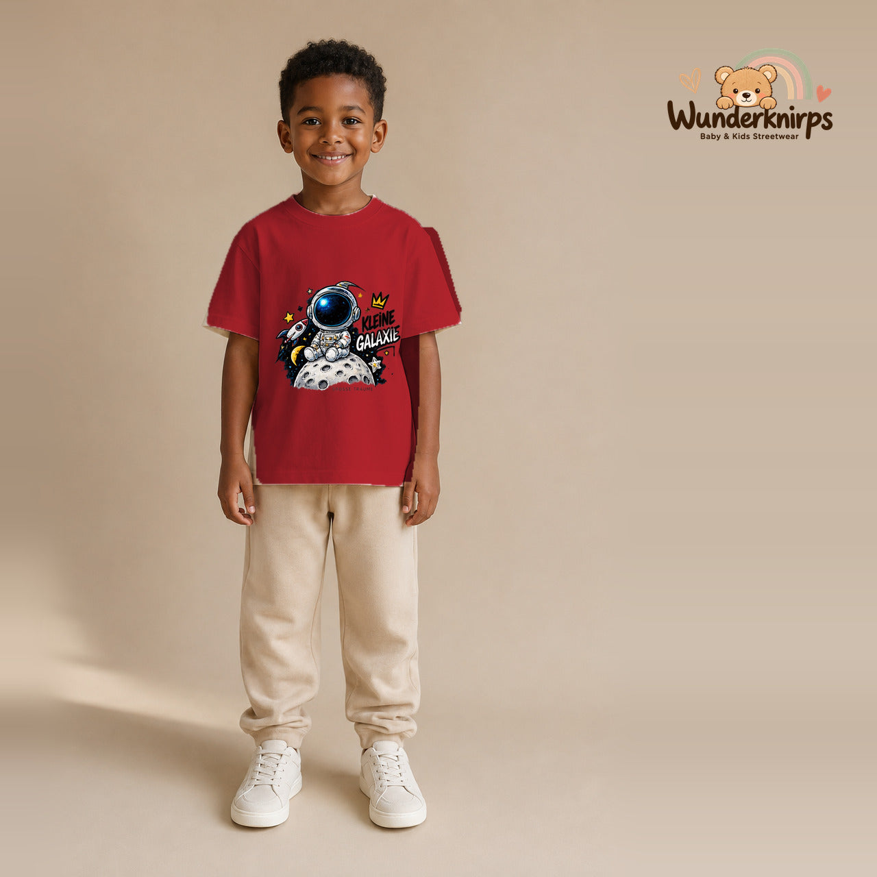 T-Shirt für Jungen in Rot mit Motiv „Kleine Galaxie“, getragen von einem Kind – Wunderknirps.