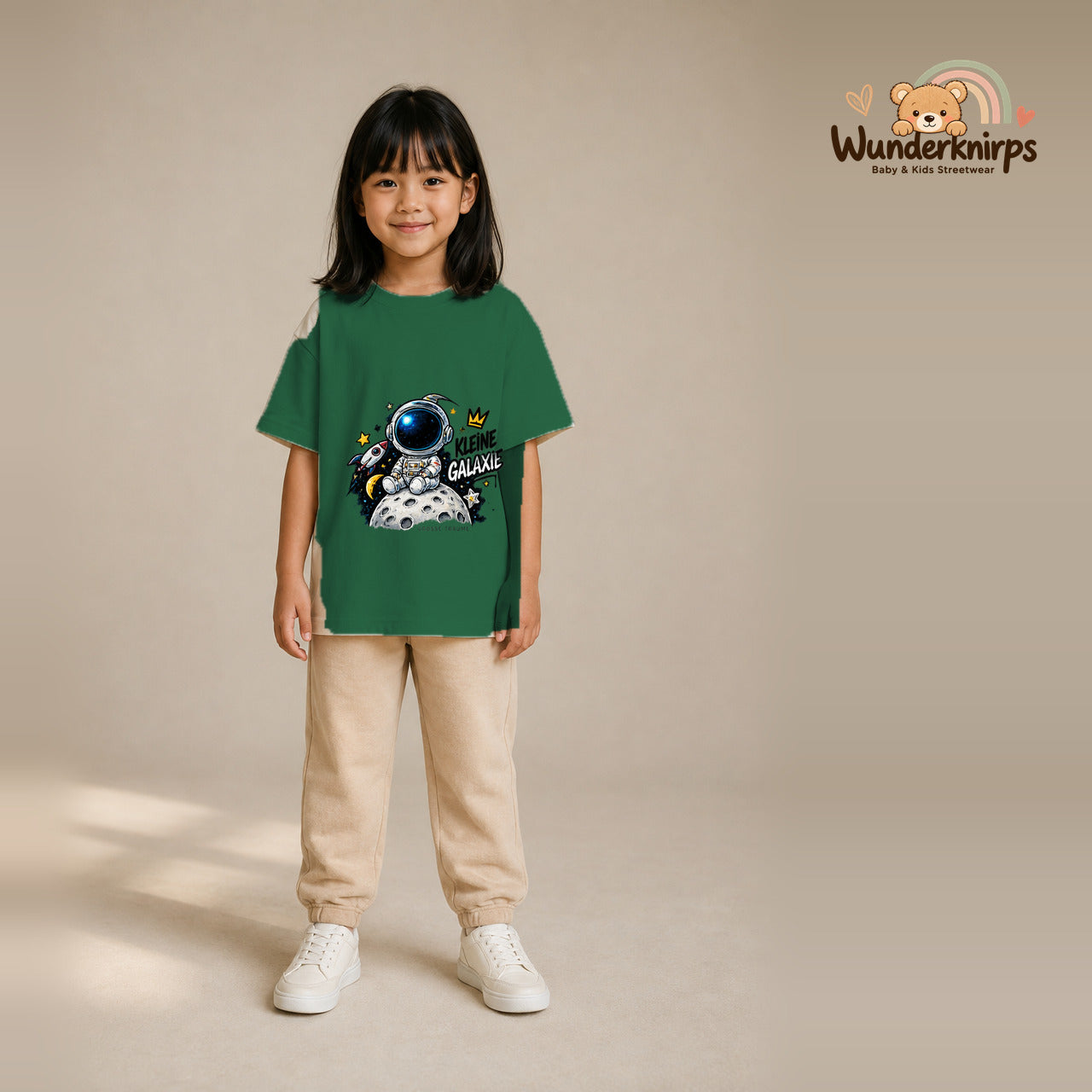 T-Shirt für Mädchen in Grün mit Motiv „Kleine Galaxie“, getragen von einem Kind – Wunderknirps.