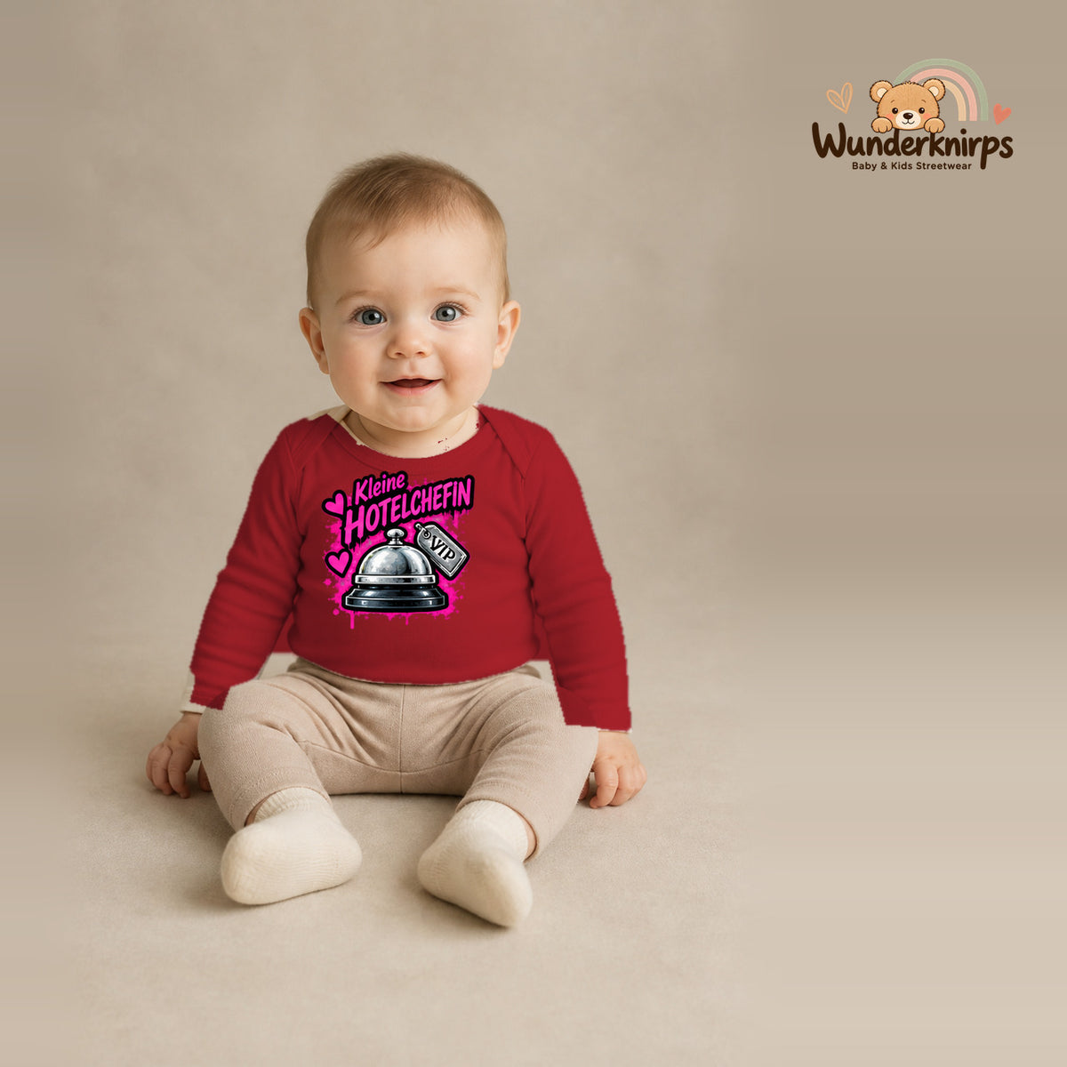 Babybody für Jungen in Rot mit Motiv „Kleine Hotelchefin“, getragen von einem Kind – Wunderknirps.