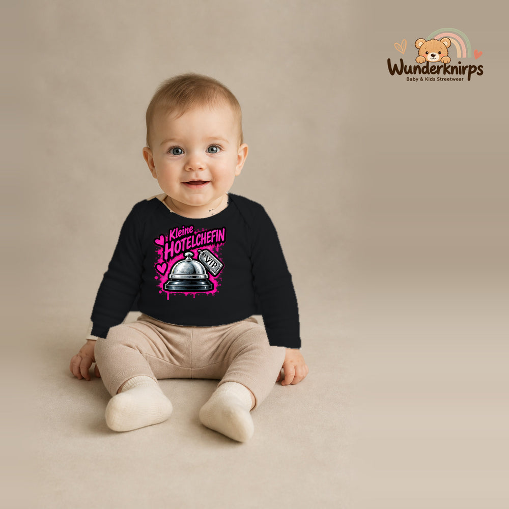 Babybody für Jungen in Schwarz mit Motiv „Kleine Hotelchefin“, getragen von einem Kind – Wunderknirps.