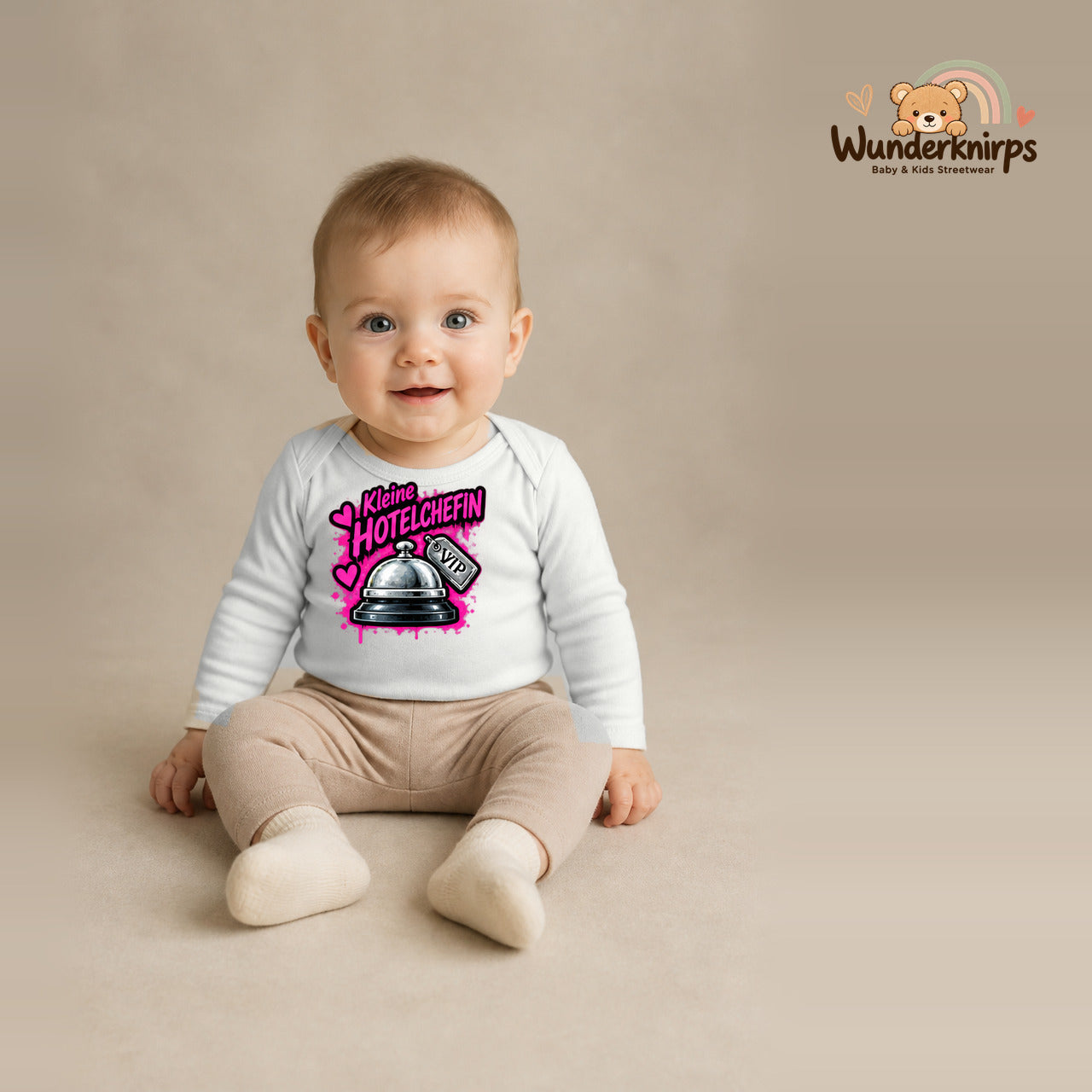 Babybody für Jungen in Weiß mit Motiv „Kleine Hotelchefin“, getragen von einem Kind – Wunderknirps.