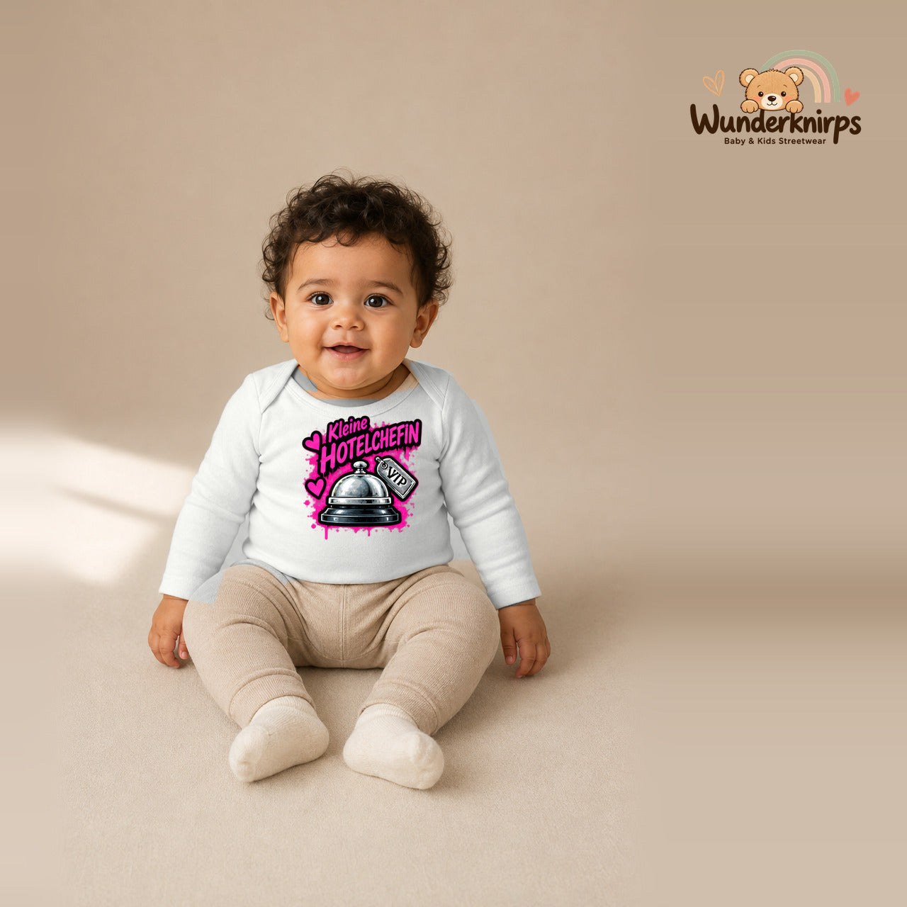 Babybody für Jungen in Weiß mit Motiv „Kleine Hotelchefin“, getragen von einem Kind – Wunderknirps.