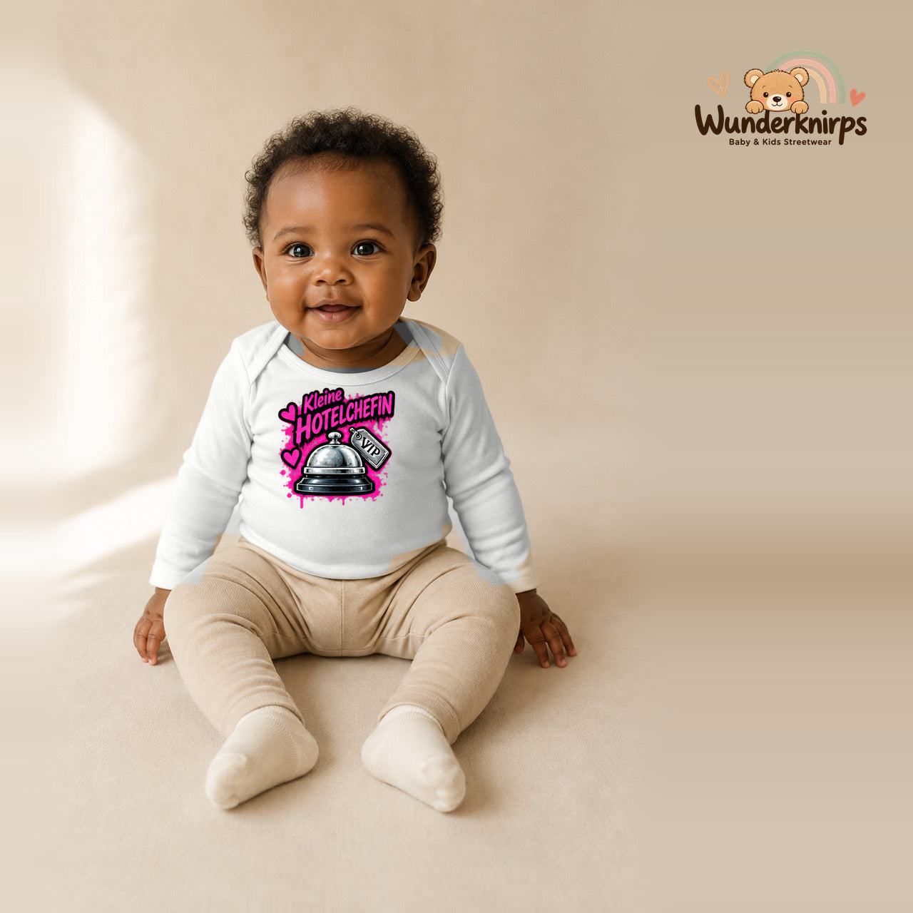 Babybody für Mädchen in Weiß mit Motiv „Kleine Hotelchefin“, getragen von einem Kind – Wunderknirps.