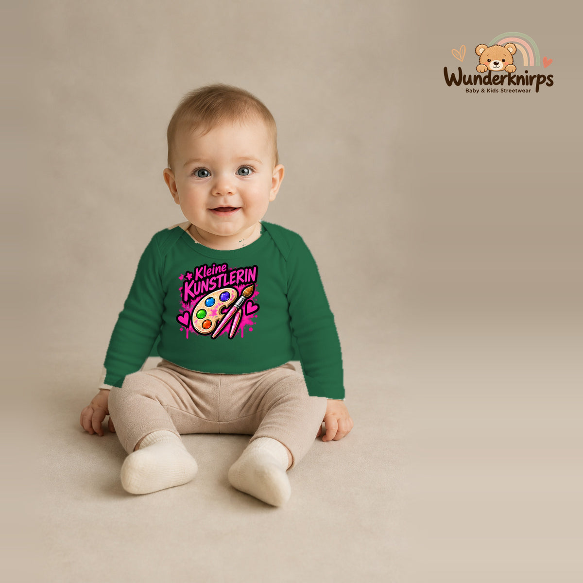 Babybody für Jungen in Grün mit Motiv „Kleine Künstlerin“, getragen von einem Kind – Wunderknirps.