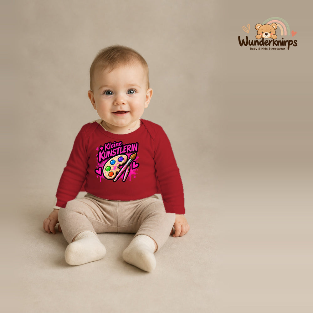 Babybody für Jungen in Rot mit Motiv „Kleine Künstlerin“, getragen von einem Kind – Wunderknirps.