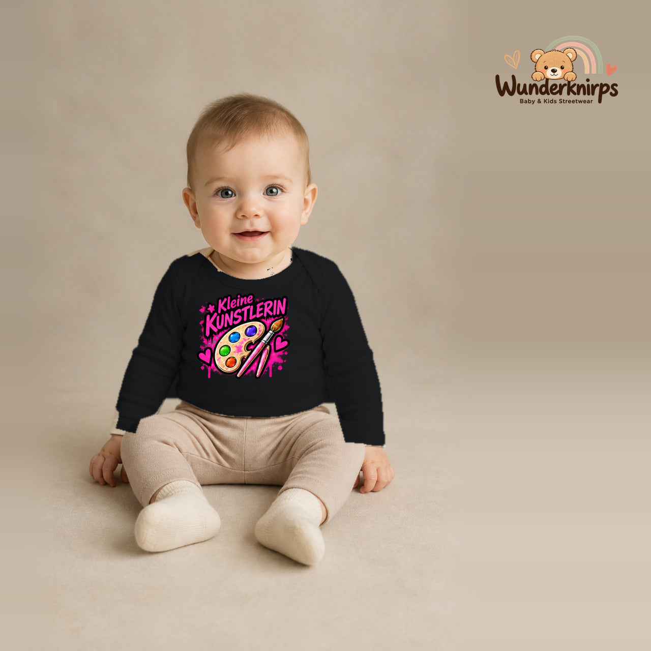 Babybody für Jungen in Schwarz mit Motiv „Kleine Künstlerin“, getragen von einem Kind – Wunderknirps.
