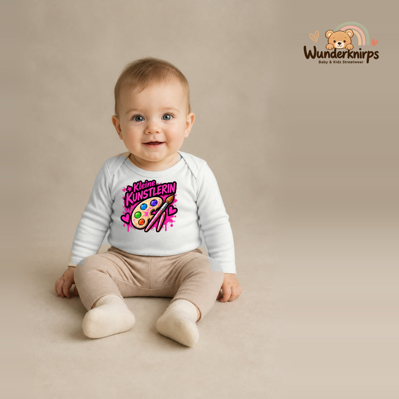 Babybody für Jungen in Weiß mit Motiv „Kleine Künstlerin“, getragen von einem Kind – Wunderknirps.