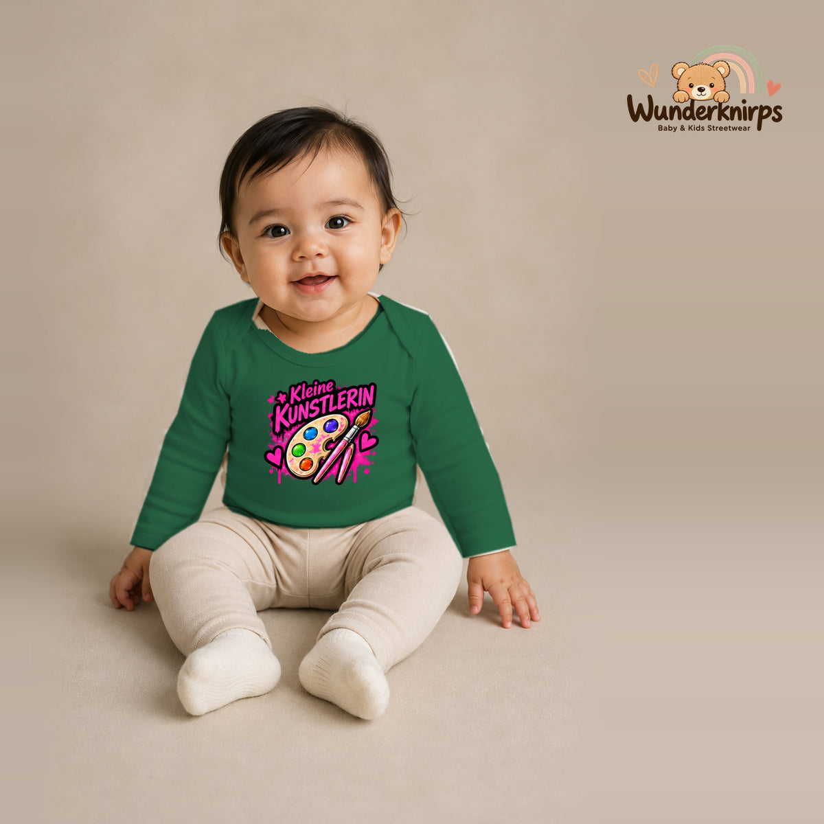 Babybody für Mädchen in Grün mit Motiv „Kleine Künstlerin“, getragen von einem Kind – Wunderknirps.