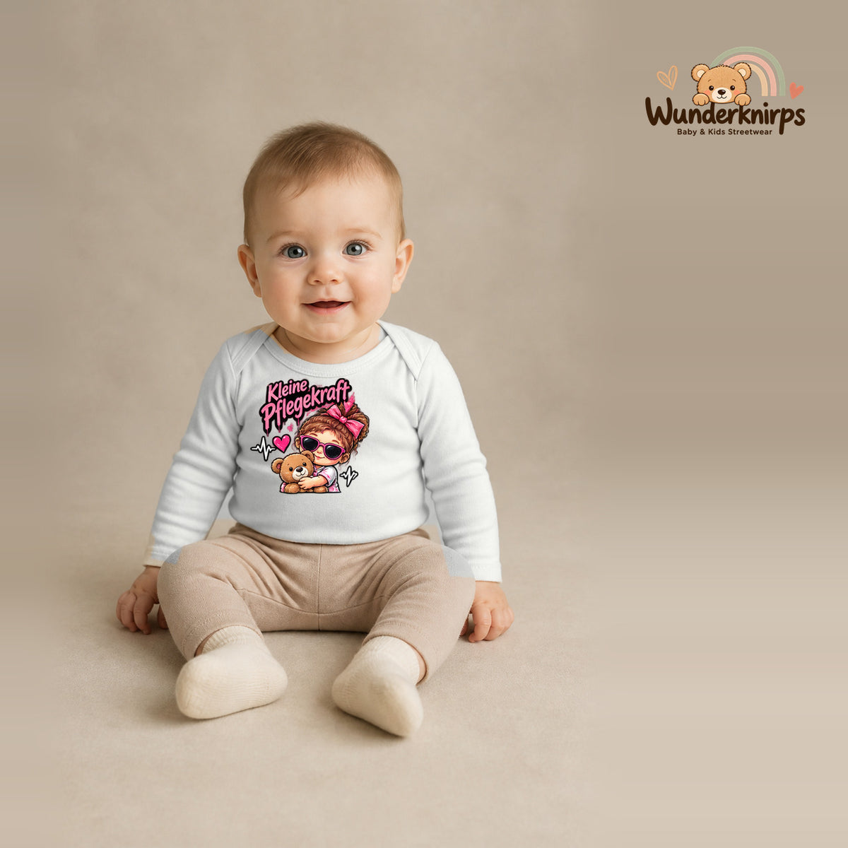 Babybody für Jungen in Weiß mit Motiv „Kleine Pflegekraft“, getragen von einem Kind – Wunderknirps.