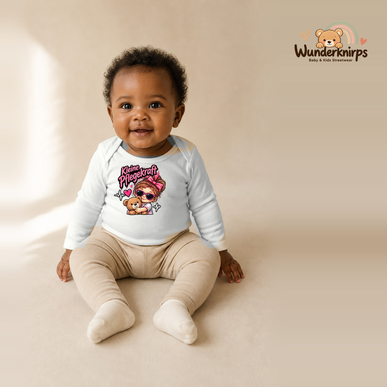 Babybody für Mädchen in Weiß mit Motiv „Kleine Pflegekraft“, getragen von einem Kind – Wunderknirps.