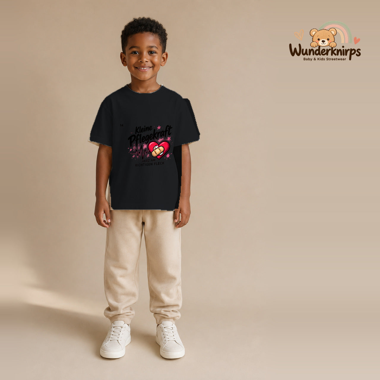 T-Shirt für Jungen in Schwarz mit Motiv „Kleine Pflegekraft“, getragen von einem Kind – Wunderknirps.