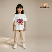 T-Shirt für Mädchen in Weiß mit Motiv „Kleine Pflegekraft“, getragen von einem Kind – Wunderknirps.