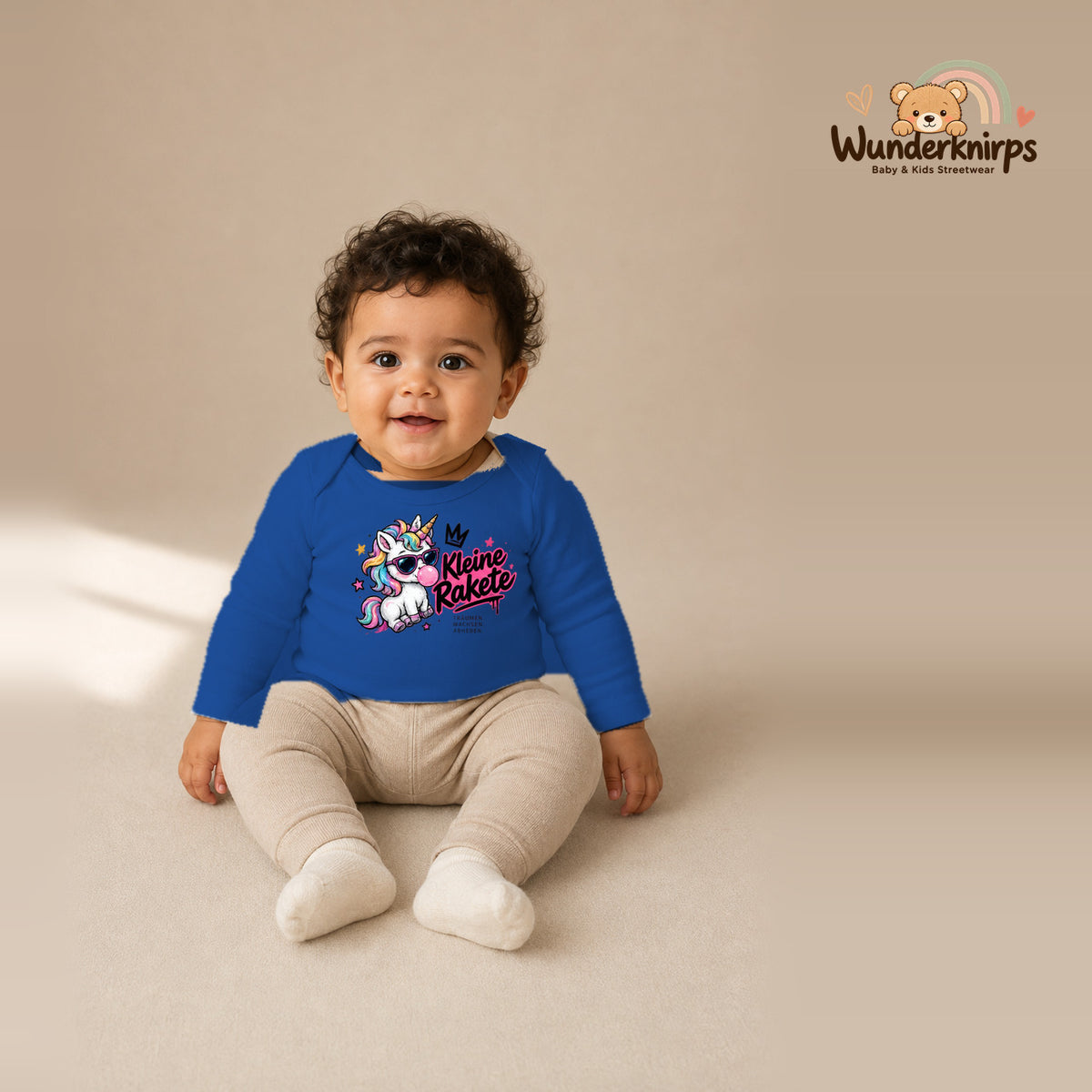 Babybody für Jungen in Blau mit Motiv „Kleine Rakete“, getragen von einem Kind – Wunderknirps.