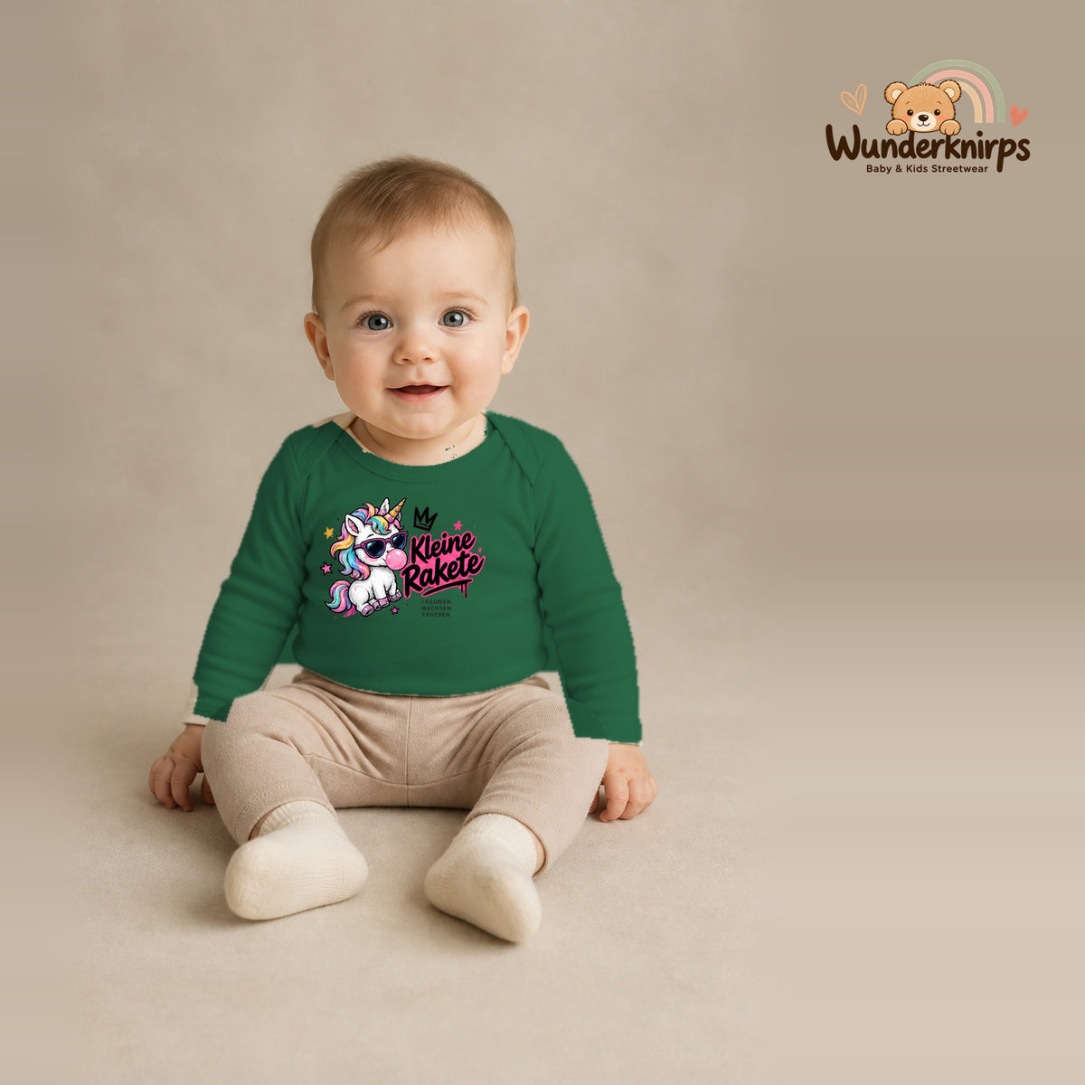 Babybody für Jungen in Grün mit Motiv „Kleine Rakete“, getragen von einem Kind – Wunderknirps.