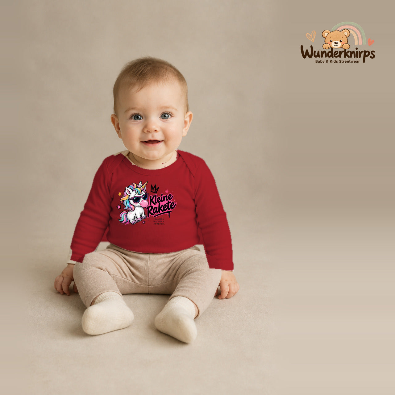 Babybody für Jungen in Rot mit Motiv „Kleine Rakete“, getragen von einem Kind – Wunderknirps.