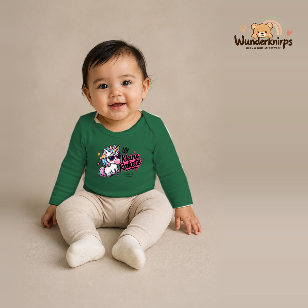 Babybody für Mädchen in Grün mit Motiv „Kleine Rakete“, getragen von einem Kind – Wunderknirps.