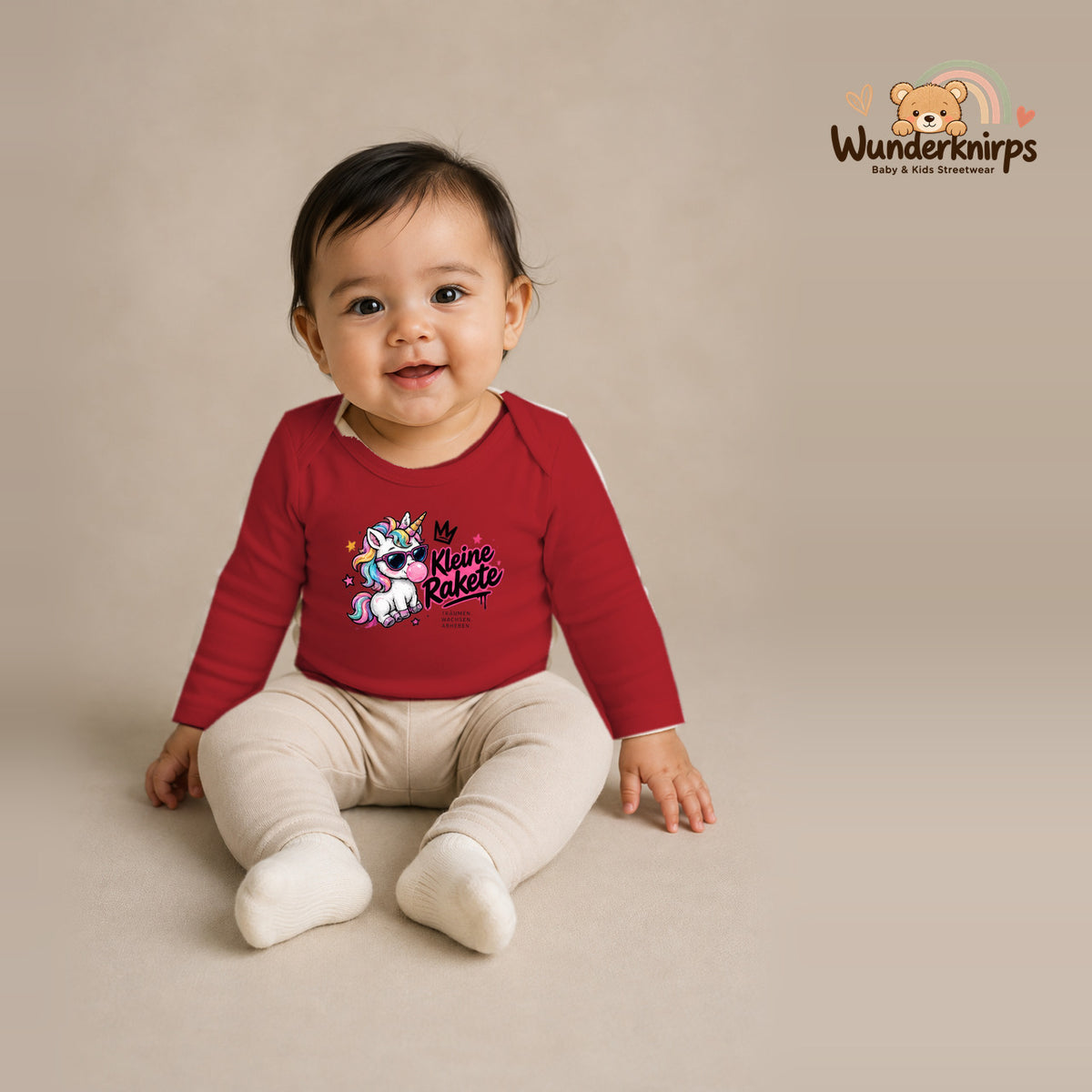 Babybody für Mädchen in Rot mit Motiv „Kleine Rakete“, getragen von einem Kind – Wunderknirps.