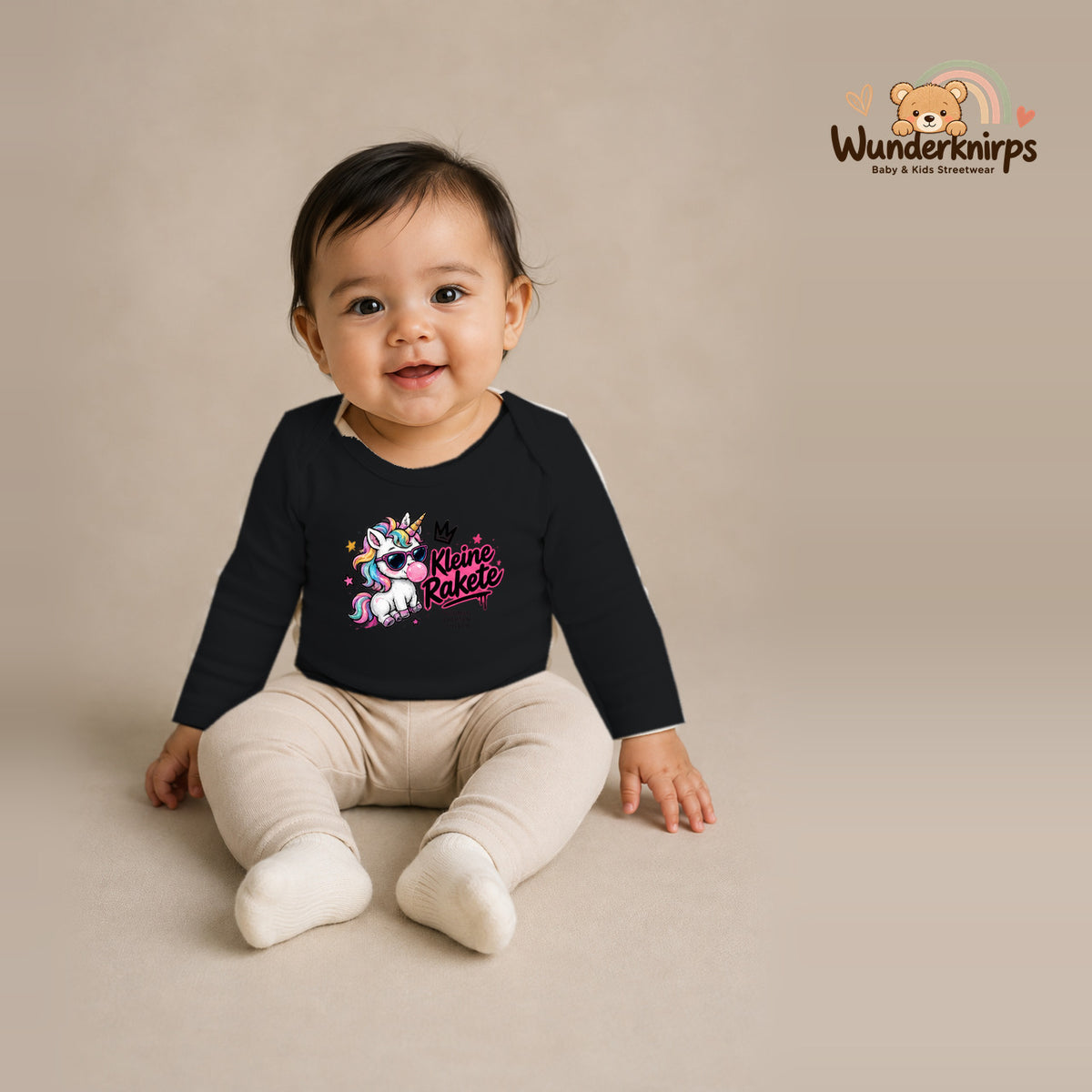 Babybody für Mädchen in Schwarz mit Motiv „Kleine Rakete“, getragen von einem Kind – Wunderknirps.