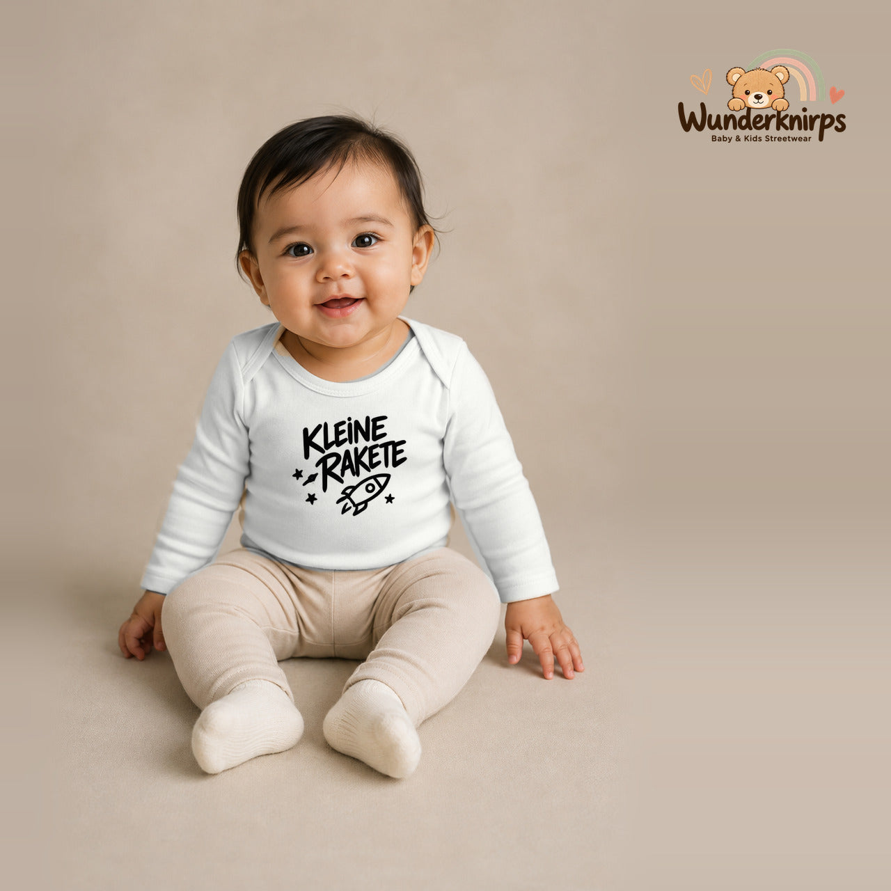 Babybody für Mädchen in Weiß mit Motiv „Kleine Rakete“, getragen von einem Kind – Wunderknirps.