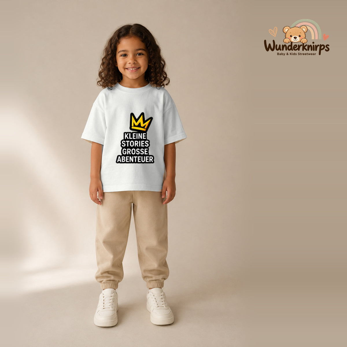 T-Shirt für Mädchen in Weiß mit Motiv „Kleine Stories große Abenteuer“, getragen von einem Kind – Wunderknirps.