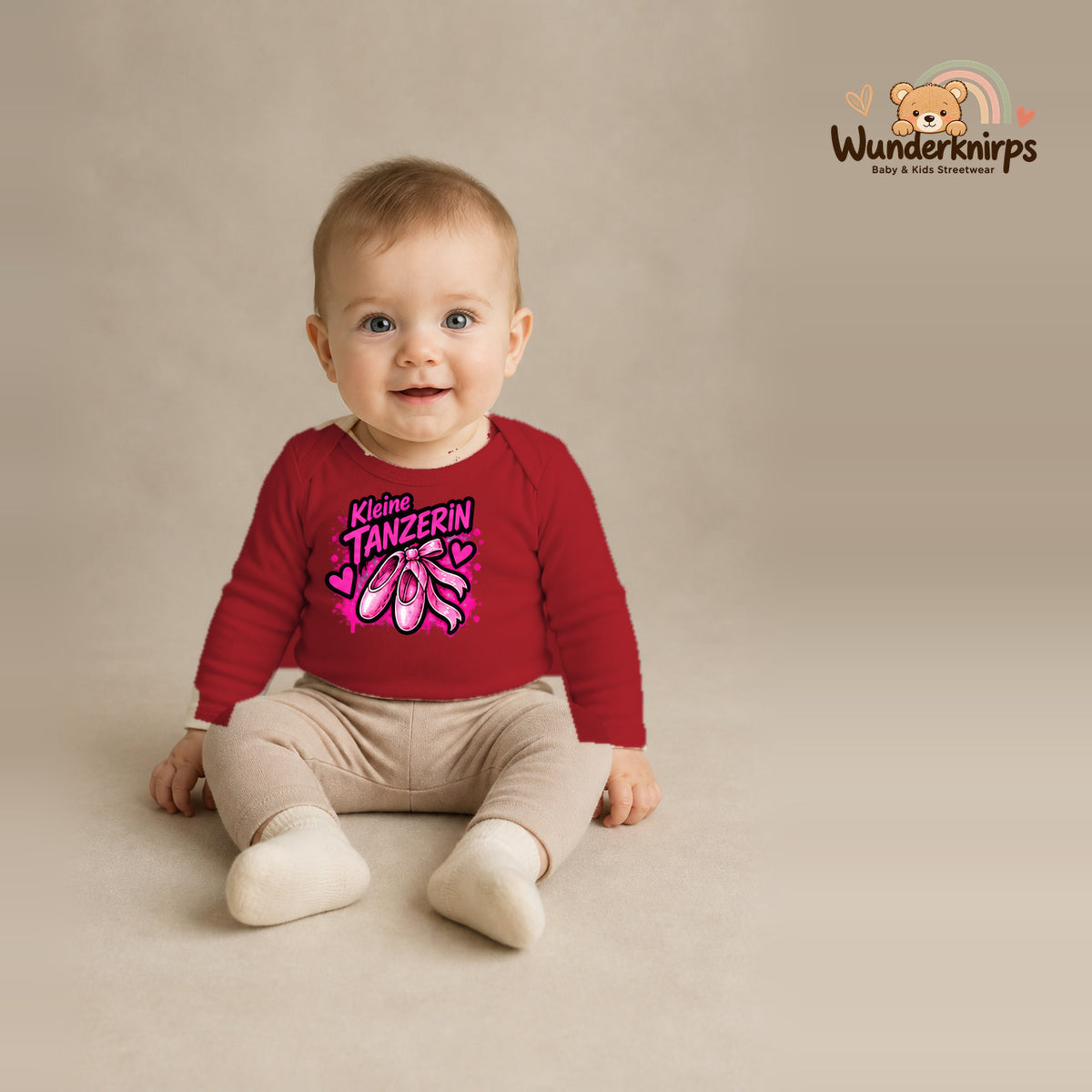 Babybody für Jungen in Rot mit Motiv „Kleine Tänzerin“, getragen von einem Kind – Wunderknirps.