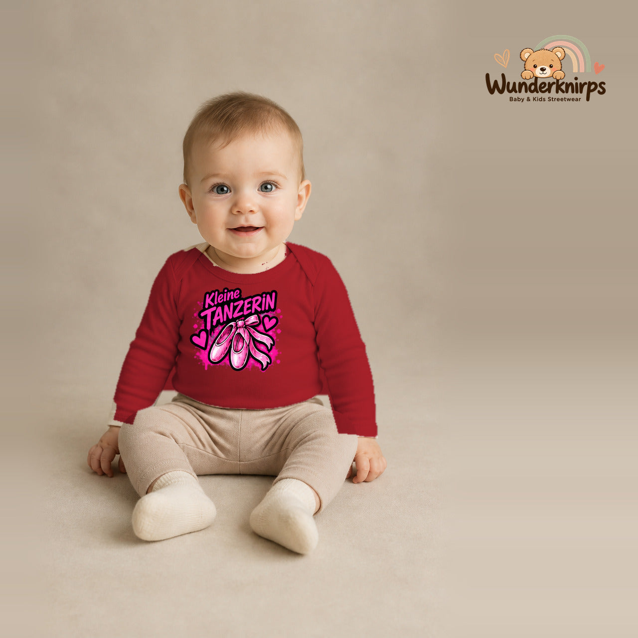 Babybody für Jungen in Rot mit Motiv „Kleine Tänzerin“, getragen von einem Kind – Wunderknirps.