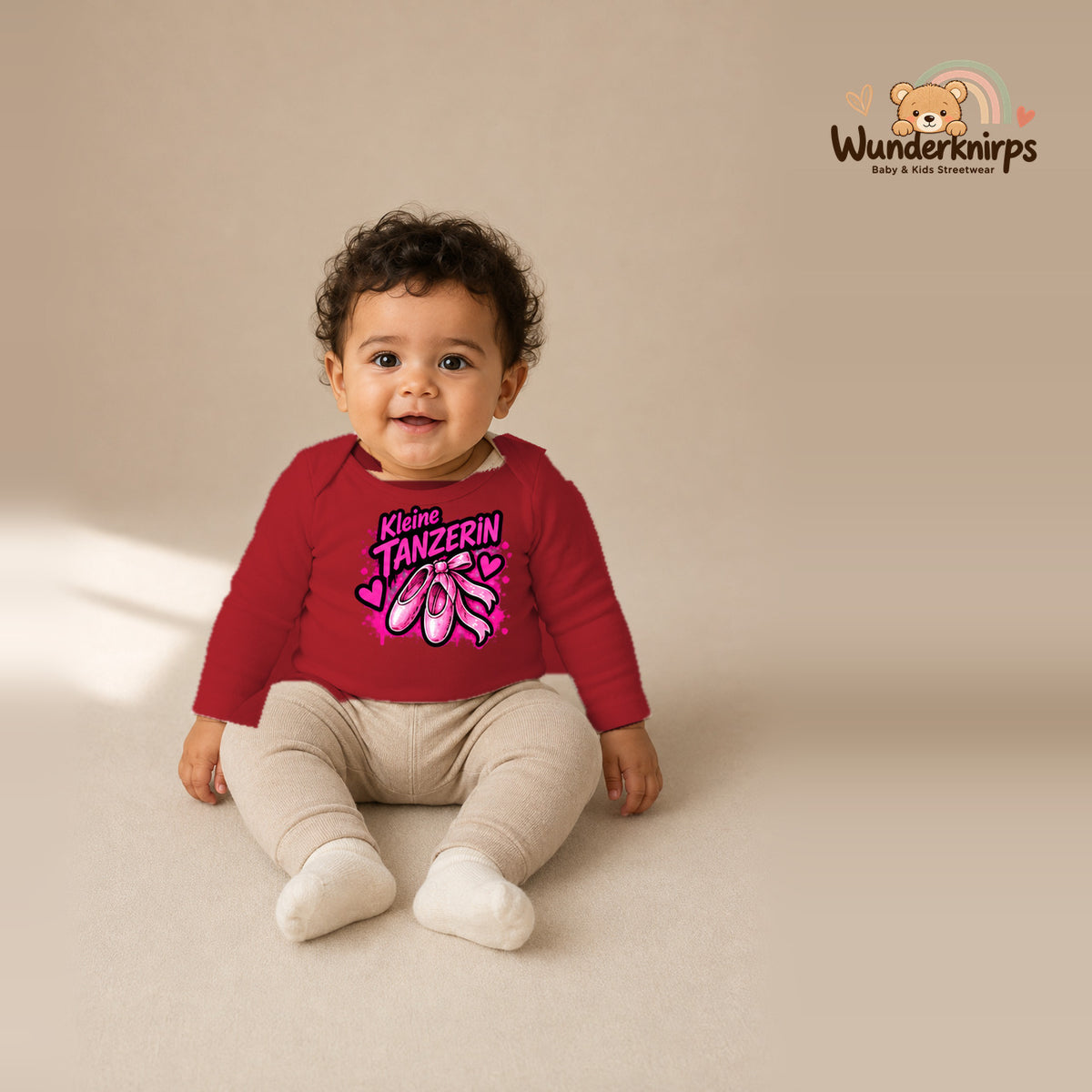 Babybody für Jungen in Rot mit Motiv „Kleine Tänzerin“, getragen von einem Kind – Wunderknirps.