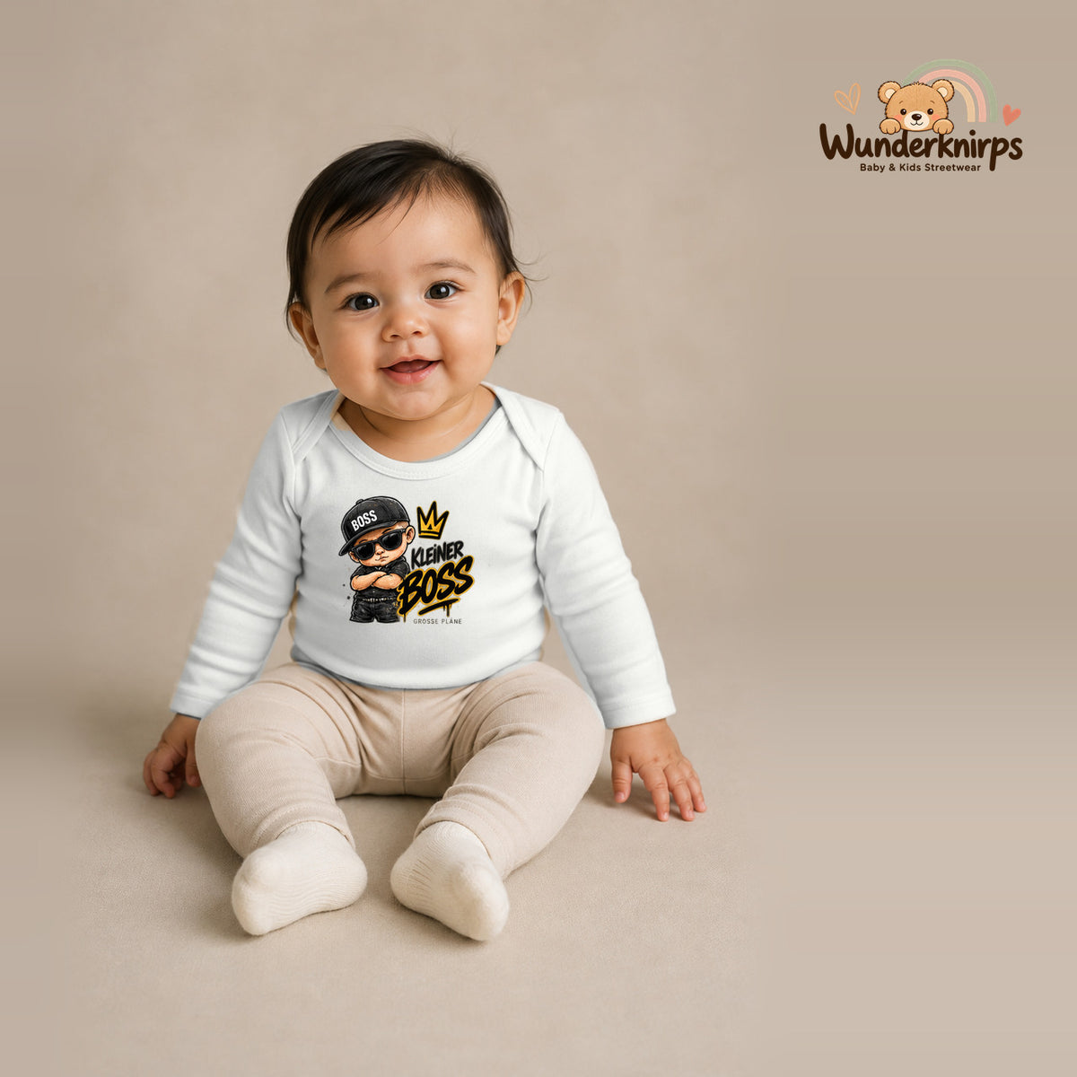 Babybody für Mädchen in Weiß mit Motiv „Kleiner Boss“, getragen von einem Kind – Wunderknirps.